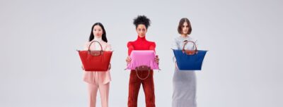 3 vrouwen houden longchamp pliage tassen voor zich vast
